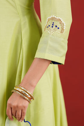 Green hand embroidered kurta sleeve close-up with pearl and blue detailing